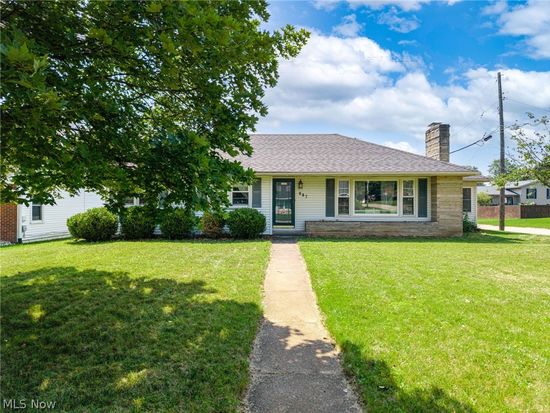White ranch home with stone chimney at 887 Arlington Ave, Mansfield, Ohio